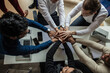 © alfa27 - Top view of businessmen standing and stacking hands over table in a meeting with copy space at mobile office. Teamwork, diversity, collaboration concept.