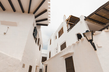 the beautiful town of binibeca on menorca. narrow streets and white walls of houses with wooden elem