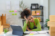© amnaj - Young business owner is experiencing stress and a headache while working on her digital tablet in her home office