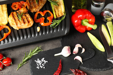 Wall Mural - Electric grill with tasty meat, spices and vegetables on grey textured table, above view