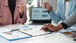 © amnaj - Business team members are using charts and graphs to analyze financial data and performance metrics during a discussion