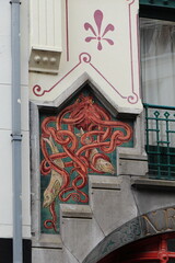 Wall Mural - Amsterdam Haarlemmerdijk Building Exterior Tiles Detail Depicting an Octopus Holding Two Fish, Netherlands