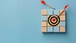 © Prime Stox - Wooden blocks with a target and arrow on a light blue background, symbolizing goal achievement and strategic planning in business. Flat lay. High quality, no realistic photo details.