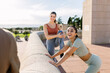 © Xavier Lorenzo - Three young fitness friends doing stretching exercise after workout routine outside. Sportive people and healthy lifestyle concept.