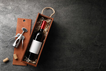 Sticker - Bottle of wine in wooden box, corks and corkscrew on dark textured table, flat lay. Space for text