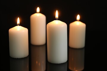 Wall Mural - Many burning candles on mirror surface against black background