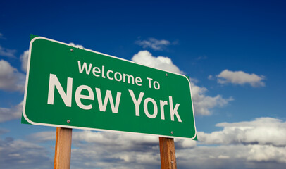 Wall Mural - Welcome To New York Green Road Sign Over Blue Sky with Some Clouds.