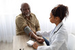 © Prostock-studio - Hypertension In Older Age. Young Female Medical Worker Measuring Arterial Blood Pressure Of Senior Black Man Using Cuff, Patient Having Problems With Tension, Sitting At Table. Health Care Concept