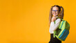 © Prostock-studio - Schoolgirl Posing With School Backpack Smiling To Camera Standing Over Yellow Background. Studio Shot