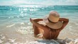 © Nicholas - A woman in a straw hat is lying on the sandy beach, enjoying the sunny weather, with the tranquil ocean waves gently lapping at her feet.