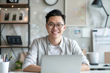 Wall Mural - Portrait of confident smiling Asian man sitting at desk