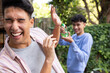 © Wavebreak Media - Laughing and spraying water, playful male gay couple enjoying outdoor fun together