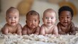 © tashechka - Close-up of four happy babies of different ethnicities lying on a soft blanket, smiling and looking at the camera.