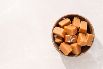 Sticker - Cubes of salted caramel in a wooden bowl