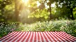 © pornsawan - Red checkered tablecloth texture top view with abstract green bokeh from white flower garden and sunlight in summer morning background,copy space.