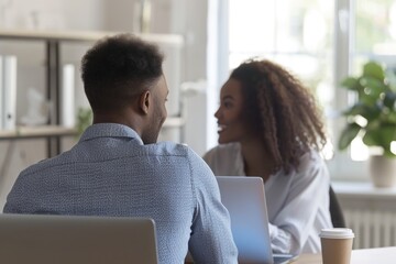 Two people working together on their computers, possibly collaborating or studying