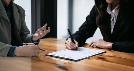 Wall Mural - businessman and woman discussing and signing a contract in office.