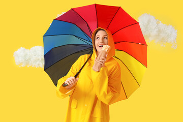 Canvas Print - Young woman in raincoat with doner kebab, umbrella and clouds on yellow background