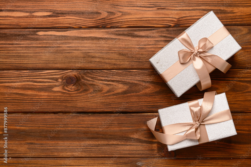 Gift boxes tied up with beige ribbon on wooden background. Top view