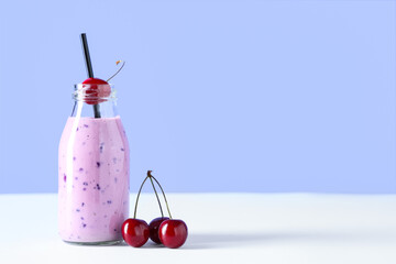 Wall Mural - Bottle of fresh smoothie with cherries on blue background