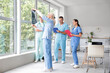 © Pixel-Shot - Group of doctors studying x-ray image near window in clinic