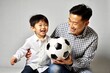 © N7 - Playful Asian Father and Son Playing Soccer