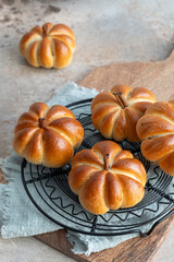 Sticker - A close up of four pumpkin shaped pastries on a black metal tray