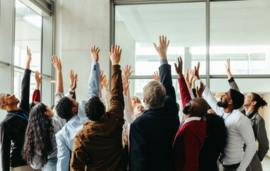 Wall Mural - excited business team raising hands at seminar in modern office building