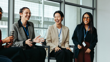 Wall Mural - diverse women enjoying group discussion in a bright modern office setting