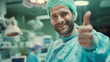 © pattozher - male doctor wear surgery uniform in operating room, smiling and thumb up