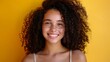 © SC Media - Close up portrait of beautiful mixed race woman with curly hair, brown eyes and freckles. the concept of protection and care with salon products, a healthy look, on a yellow background