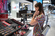 © Vladimir Razgulyaev - Woman shopping lipsticks for cosmetics in trendy store, exploring different products in fashionable setting