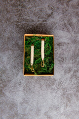 Wall Mural - White beaded earrings in the bow with the moss on a stone table