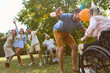 © Robert Kneschke - Outdoor celebration with friends including person in a wheelchair enjoying a party