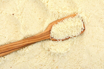 Wall Mural - Almond flour in a wooden spoon  background.