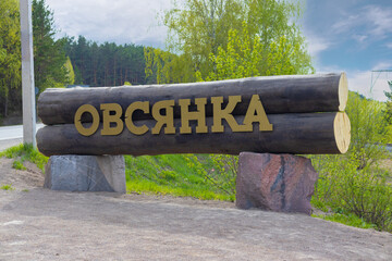 Letters OVSYANKA on logs near the road before entering the village. Ovsyanka village is known as the birthplace of the Russian writer Viktor Astafyev