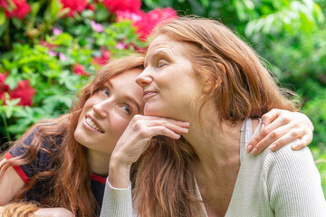 Two Redheads Hugging in Garden During Day