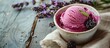© meristock - Copy space image of a rustic white napkin displaying a biscuit cup holding a scoop of blackberry blueberry ice cream, garnished with lavender flowers in a horizontal view.