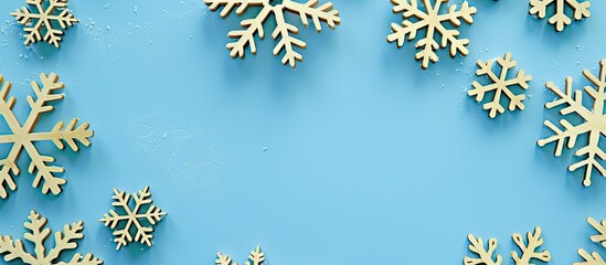 Poster - Close-up view of decorative wooden Christmas snowflakes on a blue background, creating a festive New Year card with creative copy space image.