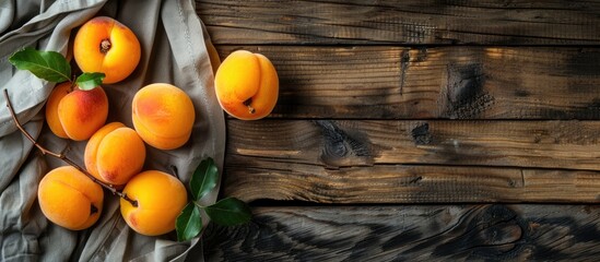Poster - Close-up of ripe apricots on a wooden table with a napkin, copy space image.