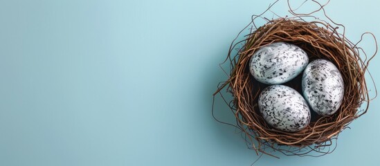 Poster - Creative hand-painted silver eggs rest in a decorative bird nest on a blue pastel background, forming an Easter-themed copy space image.