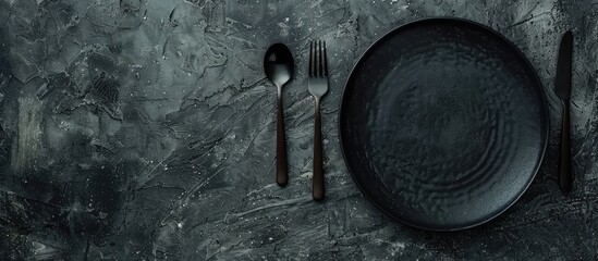 Poster - Dark textured concrete background showcases an empty ceramic round plate with cutlery, an inviting copy space image for a dinner setting.