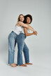 © Bliss - Two women in tank tops and jeans smile as they pose for the camera, with the woman on the left arm around the woman on the right