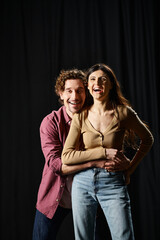 A good-looking man and woman strike elegant poses during theater rehearsals.