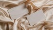© Ailee Tian - Two blank business cards on beige silk fabric, mockup design template.