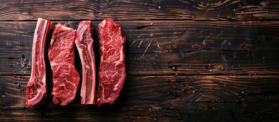 Wall Mural - Top view of prime black Angus beef steaks like Fillet Mignon, rib eye, Striploin, or New York, on a dark wooden background with copy space image.