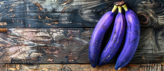 Wall Mural - Top-down view of delicious purple bananas on a wooden surface with sufficient copy space for text.