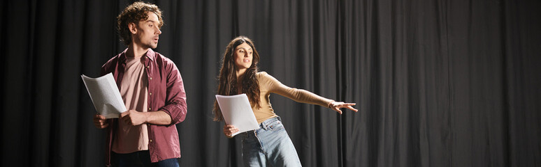 Wall Mural - Man and woman stand together on stage during theater rehearsals.