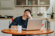 © ADDICTIVE STOCK - Frustrated young man working from home on a laptop