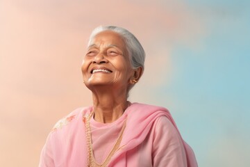 Poster - Portrait of a blissful indian elderly woman in her 90s dressed in a water-resistant gilet on pastel or soft colors background